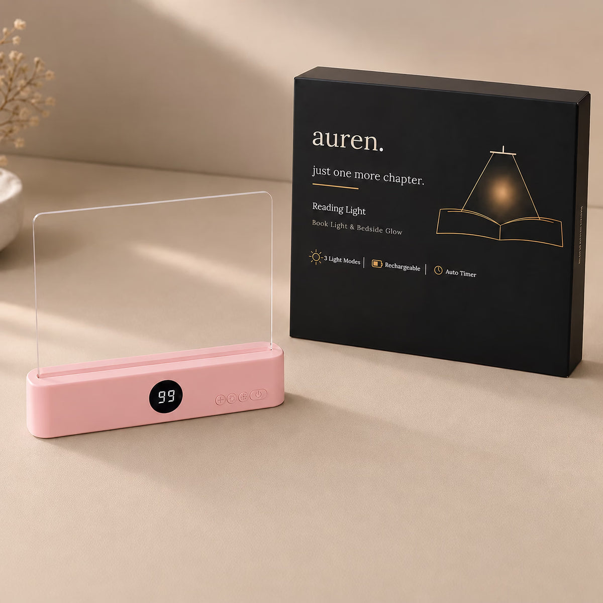 Pink Auren reading light with clear panel and black retail box on a beige surface.